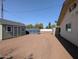 This home features a shed, blue dumpster, and open gravel lot with a home on the right side of the frame at 4145 E Libby St, Phoenix, AZ 85032