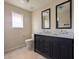 This bathroom is equipped with a modern vanity, dual mirrors, and a toilet near a window at 4145 E Libby St, Phoenix, AZ 85032