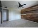 This cozy bedroom boasts a rustic wood accent wall, soft carpet, and ample closet space at 4145 E Libby St, Phoenix, AZ 85032