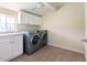Bright laundry room featuring modern washer and dryer, white cabinetry, and wood-look floors at 4145 E Libby St, Phoenix, AZ 85032