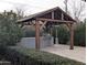 Outdoor kitchen features a grill, cooking area, and two standing heaters set in a wood framed enclosure with a stone paver floor at 4145 E Libby St, Phoenix, AZ 85032