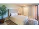 Bedroom features a queen bed with soft linens and a large potted plant, and a sliding door closet at 4303 E Cactus Rd # 326, Phoenix, AZ 85032