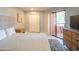 Bedroom with a queen bed, dresser, sliding door closet, and access to a private balcony at 4303 E Cactus Rd # 326, Phoenix, AZ 85032