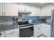 Close-up kitchen view of updated range, stainless steel appliances, granite countertop, and modern backsplash at 4303 E Cactus Rd # 326, Phoenix, AZ 85032