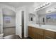 Bathroom with a large mirror, single sink vanity, and a view into another room at 4552 S 238Th Ln, Buckeye, AZ 85326
