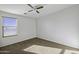 Bright bedroom showcasing neutral walls, ceiling fan, and a bright window view at 4552 S 238Th Ln, Buckeye, AZ 85326