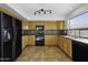 Traditional kitchen with wood cabinets, black appliances, and neutral backsplash at 4552 S 238Th Ln, Buckeye, AZ 85326