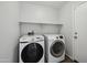 Bright laundry room with a modern Samsung washer and dryer, and a white shelf for storage at 4552 S 238Th Ln, Buckeye, AZ 85326