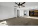 Spacious living room open to kitchen with ceiling fan, arched openings, and neutral walls at 4552 S 238Th Ln, Buckeye, AZ 85326