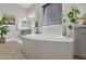 This bathroom features a soaking tub with quartz surround, neutral tile floor, and natural light from the window at 4639 N 29Th St, Phoenix, AZ 85016