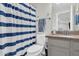 A neutral-toned bathroom featuring a vanity with granite top, toilet and blue and white striped shower curtain at 4639 N 29Th St, Phoenix, AZ 85016