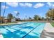 Large community swimming pool with clear blue water surrounded by well-maintained landscaping and palm trees at 4800 N 68Th St # 263, Scottsdale, AZ 85251
