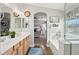 Bright bathroom with double vanity sinks, modern tub, wood-like floors, and an arched doorway leading into a sunlit bedroom at 4979 E Colonial Dr, Chandler, AZ 85249