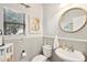 Cozy half-bathroom with a round mirror and neutral color scheme at 4979 E Colonial Dr, Chandler, AZ 85249