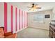 Bedroom featuring a chair, dresser, a window with blinds, carpet floors, pink stripes, and a ceiling fan at 4979 E Colonial Dr, Chandler, AZ 85249