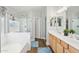 Bathroom featuring double sinks, wood cabinets, bathtub, and a separate glass-enclosed shower at 4979 E Colonial Dr, Chandler, AZ 85249