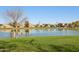 Community pond featuring grassy area, walking path, park bench, and neighborhood homes at 4979 E Colonial Dr, Chandler, AZ 85249