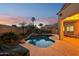 Twilight view of the backyard pool highlighting the desert landscaping and tranquil atmosphere at 4979 E Colonial Dr, Chandler, AZ 85249