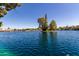 Picturesque lake view with an island of mature trees and waterfront homes in the background at 5200 S Lakeshore Dr # 106, Tempe, AZ 85283