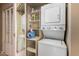 Convenient laundry closet featuring a stackable washer and dryer with built in shelving at 5200 S Lakeshore Dr # 106, Tempe, AZ 85283