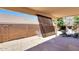 Covered patio features stone flooring, shade screen, desert landscaping, and outdoor seating at 6408 W Prickly Pear Trl, Phoenix, AZ 85083