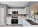 Well-lit kitchen with white cabinets, stainless steel appliances, and ample counter space at 6408 W Prickly Pear Trl, Phoenix, AZ 85083