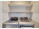Modern laundry room featuring stainless steel washer and dryer, complemented by convenient shelving at 6408 W Prickly Pear Trl, Phoenix, AZ 85083