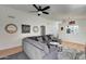 Open-concept living room offers a ceiling fan, hardwood floors, and a comfortable gray sectional sofa, perfect for relaxing at 6408 W Prickly Pear Trl, Phoenix, AZ 85083