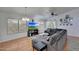 Spacious living room features large windows, hardwood floors, a ceiling fan, and a comfortable gray sectional sofa at 6408 W Prickly Pear Trl, Phoenix, AZ 85083
