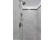 Tiled shower features large stone-look tiles, a niche, and modern fixtures at 6408 W Prickly Pear Trl, Phoenix, AZ 85083