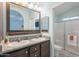 Bathroom featuring double sinks, dark-wood cabinets, and a glass-enclosed shower with updated fixtures at 650 N Hawes Rd # 2873, Mesa, AZ 85207
