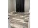 An empty bedroom featuring gray walls, light-colored trim, laminate flooring, and a window with black-out curtains at 6607 W Osborn Rd, Phoenix, AZ 85033