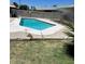 Backyard pool with white concrete trim, surrounded by a green lawn and block fence at 6607 W Osborn Rd, Phoenix, AZ 85033