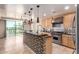 An open floor plan kitchen with stainless appliances, wooden cabinets, and a cooktop oven at 6803 E Main St # 3306, Scottsdale, AZ 85251