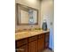 Bathroom features a granite vanity with a mirror and wood cabinets for storage at 6901 W Marco Polo Rd, Glendale, AZ 85308