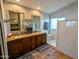 A modern bathroom features a double vanity, granite counters, and a step-in shower with natural light at 6901 W Marco Polo Rd, Glendale, AZ 85308