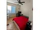 Bright bedroom with a ceiling fan, neutral walls, and a red bedspread at 6901 W Marco Polo Rd, Glendale, AZ 85308