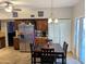 Eat-in kitchen area with a dining table and chairs, stainless steel fridge, and bi-fold doors at 6901 W Marco Polo Rd, Glendale, AZ 85308