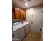 Functional laundry room with wooden cabinets and a side-by-side washer and dryer at 6901 W Marco Polo Rd, Glendale, AZ 85308