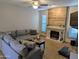 Cozy living room features a comfortable sectional sofa, tiled fireplace, and tile floors at 6901 W Marco Polo Rd, Glendale, AZ 85308