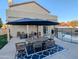 Outdoor patio with table, chairs, grill, and covered seating area next to a pool surrounded by a safety fence at 6901 W Marco Polo Rd, Glendale, AZ 85308