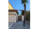 Side exterior of a house with a light beige exterior and a wooden gate, as well as desert landscaping at 6901 W Marco Polo Rd, Glendale, AZ 85308