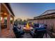 Spacious backyard featuring a cozy fire pit area with comfortable seating and serene twilight views at 706 E La Palta St, Queen Creek, AZ 85140