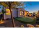Picturesque backyard featuring a putting green, covered patio, fire pit, and desert plants at 706 E La Palta St, Queen Creek, AZ 85140