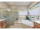 A luxurious bathroom features a large soaking tub, a glass-enclosed shower, and a window with natural light at 706 E La Palta St, Queen Creek, AZ 85140