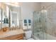 A well-lit bathroom features a glass shower, wood cabinets, granite countertops, and a framed mirror at 706 E La Palta St, Queen Creek, AZ 85140
