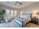 Bright bedroom features a ceiling fan, large windows, and a cozy armchair at 706 E La Palta St, Queen Creek, AZ 85140