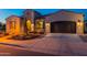 Charming home exterior with desert landscaping, decorative shutters, arched entry and a two-car garage at 706 E La Palta St, Queen Creek, AZ 85140