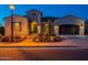Charming home exterior with desert landscaping, decorative shutters, arched entry and a two-car garage at 706 E La Palta St, Queen Creek, AZ 85140