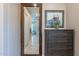 Hallway view features a beautiful, dark wood dresser with framed art and a glimpse into the bright bathroom at 706 E La Palta St, Queen Creek, AZ 85140